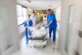 Medici e infermieri conducono un malato su un lettino d'ospedale