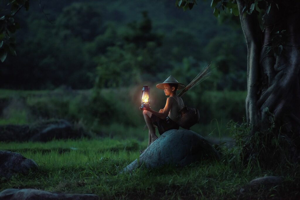 Un ragazzo accende una lanterna in una campagna del Vietnam