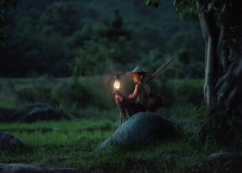 Un ragazzo accende una lanterna in una campagna del Vietnam