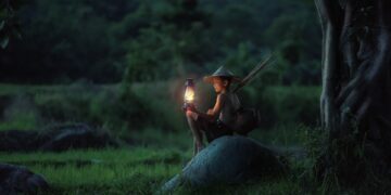 Un ragazzo accende una lanterna in una campagna del Vietnam