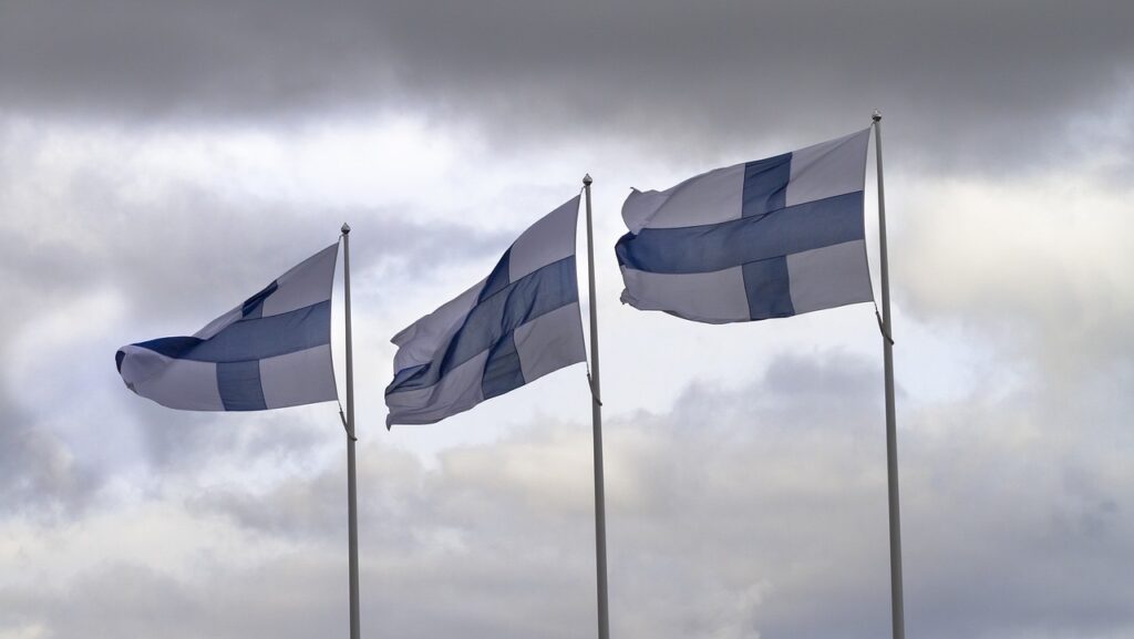 Tre bandiere della Finlandia che sventolano nel cielo nuvoloso