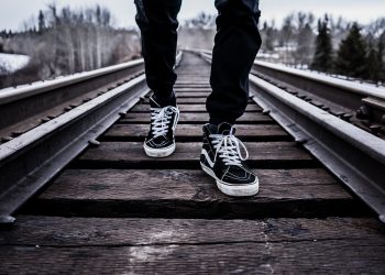 Un ragazzo cammina sulle rotaie