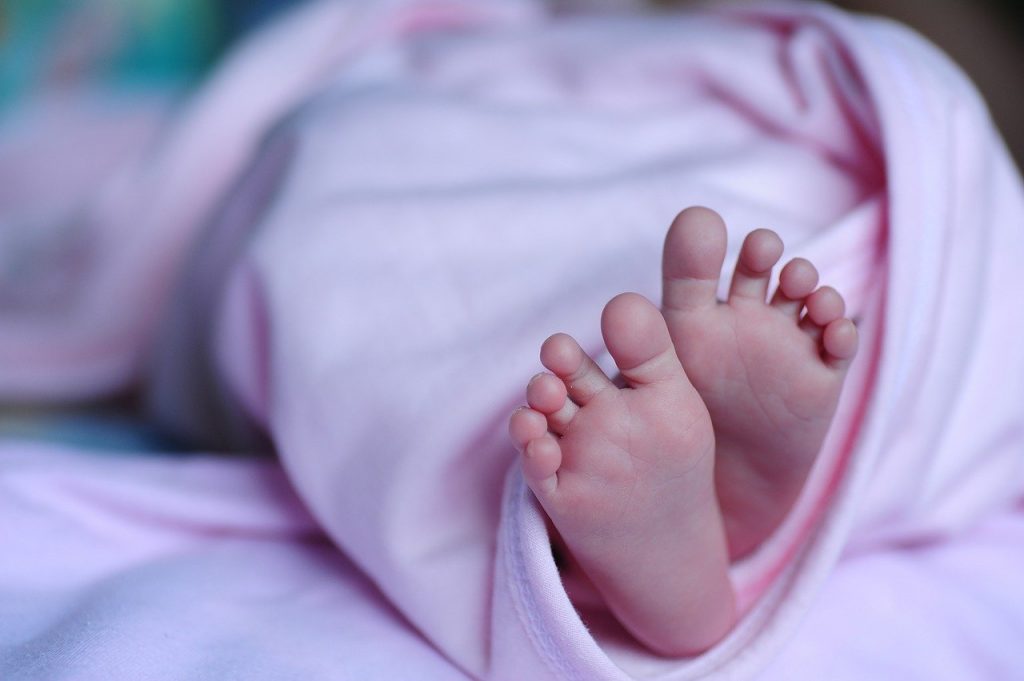 Baby girl's feet wrapped in a pink blanket