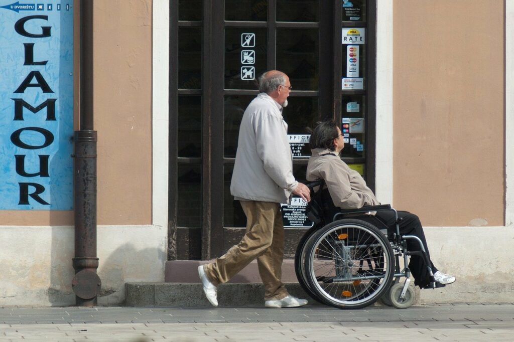 Un familiare spinge una donna in sedia a rotelle