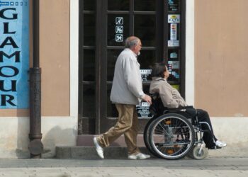 Un familiare spinge una donna in sedia a rotelle