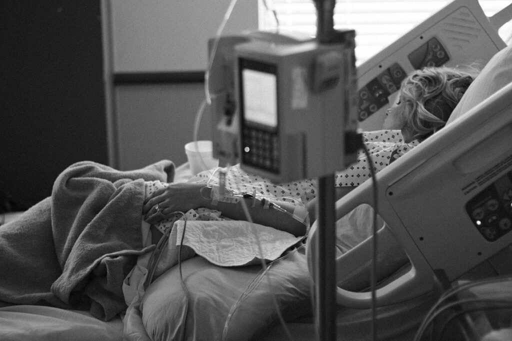 Donna in un letto d'ospedale, bianco e nero