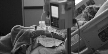 Donna in un letto d'ospedale, bianco e nero