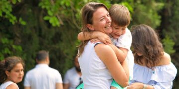 Mamma che ride con figlio in braccio