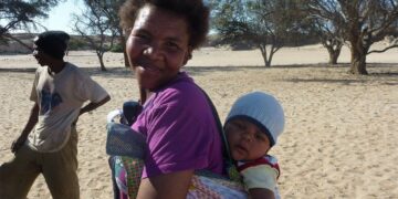 Donna con bambino in fascia sulle spalle, in Namibia